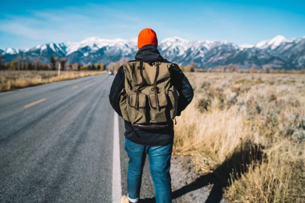 男子徒步旅行者 背负着时髦的背包 独自穿过大路 走到山巅 带着背包步行到国家公园的目的地 花时间去冒险 — 图库照片