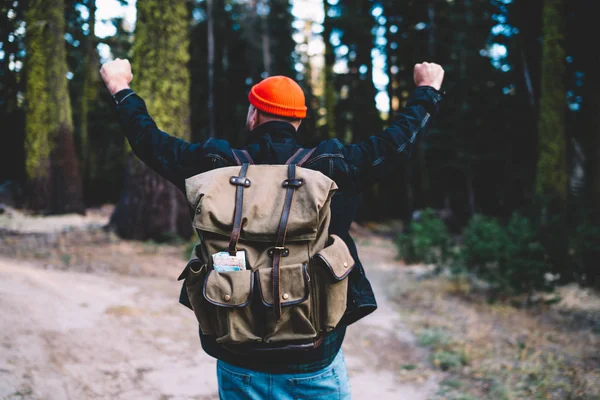 兴奋的男性徒步旅行者举起双臂 与绿树一起探索大自然的野性环境 快乐的 金丝雀 背包客在远足的旅途中 感觉在森林中度过了一段美好的时光 — 图库照片