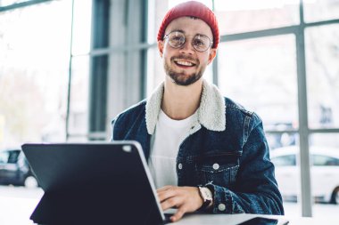 Gülümseyen erkek serbest girişimci yeni bir proje üzerinde çalışıyor. İnternet araştırmacılarını laptop bilgisayarı ve kablosuz internet bağlantısı kullanarak verileri analiz etmeye zorluyor. 