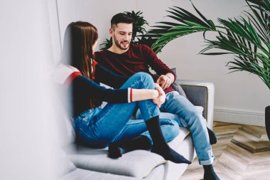 Birbirine aşık çiftler ilişki hakkında iletişim kurarken rahat ev içlerinde vakit geçiriyorlar, genç evlilikler modern apartman dairesinde sohbet ediyorlar rahat bir koltukta dinleniyorlar.