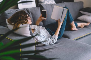 Akıllı genç kadın rahat bir kanepede uzanıyor ve kendi odasında ilginç kitaplar okuyor. Akıllı hippi kız elinde telefon tutuyor ve boş zamanlarında koltukta dinlenerek en çok satan kitaplardan hoşlanıyor.