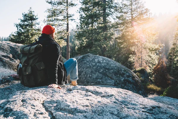 年轻的男性旅行者坐在高高的岩石悬崖上 凝视着令人叹为观止的自然景观 他们积极地度过周末 嬉皮士则在山顶上享受着漫游情欲的冒险 — 图库照片