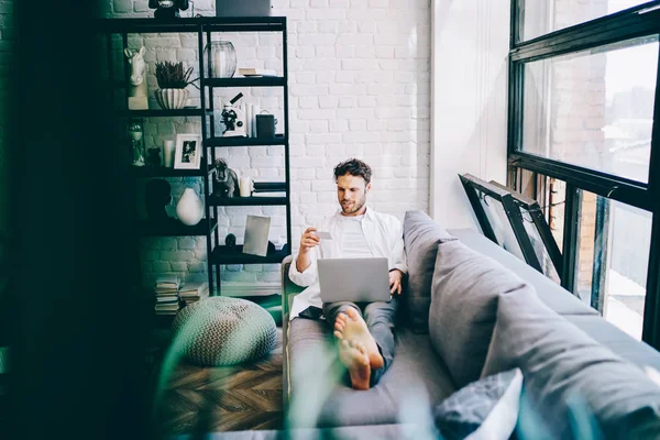 Vrolijke Hipster Man Rusten Bank Modern Ingerichte Woonkamer Maken Van — Stockfoto