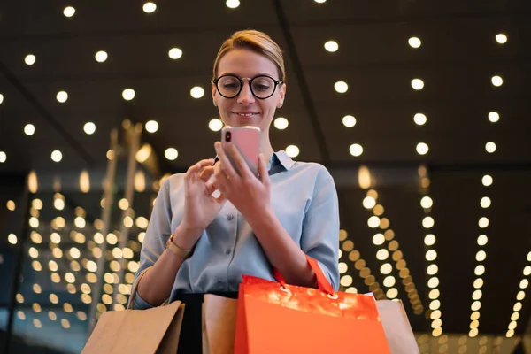 Leende Kvinnlig Kund Glasögon Står Utomhus Med Shoppingväskor Och Använder — Stockfoto