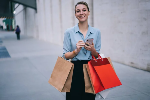 Halvlångt Porträtt Upphetsad Kvinnlig Köpare Står Reklamområdet Med Papperspaket Och — Stockfoto