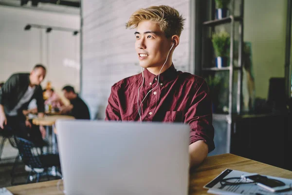 Freelancer Masculino Asiático Bem Sucedido Olhando Para Longe Enquanto Ouve — Fotografia de Stock