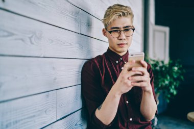 Görme düzeltmesi için optik gözlük takan ciddi Japon erkek blogcu, kapalı alanlarda ücretsiz internet bağlantısı kullanarak akıllı telefon uygulaması tebligatı hakkında aldığı e-postada şaşkın hissediyor