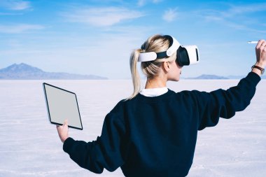 Sanal gerçeklik kulaklığıyla el hareketleriyle resim çizen ve tablet bilgisayar kullanarak açık hava mekanları tasarlayan kadınların arka planı. Kadın mimar VR şehir altyapısı yaratıyor