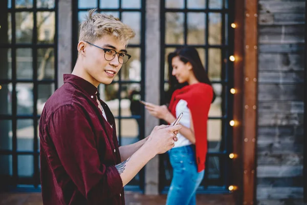 Knappe Chinese Hipster Kerel Bril Weg Kijken Terwijl Berichten Smartphone — Stockfoto