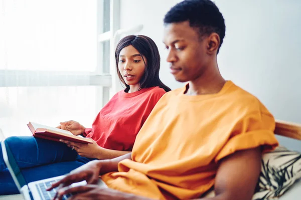 严重的非洲裔美国女人看着她的男朋友在笔记本电脑搜索网站上打字 以便在卧室里进行在线预订 通过Netboo在网上商店购买深色皮肤的夫妻 — 图库照片