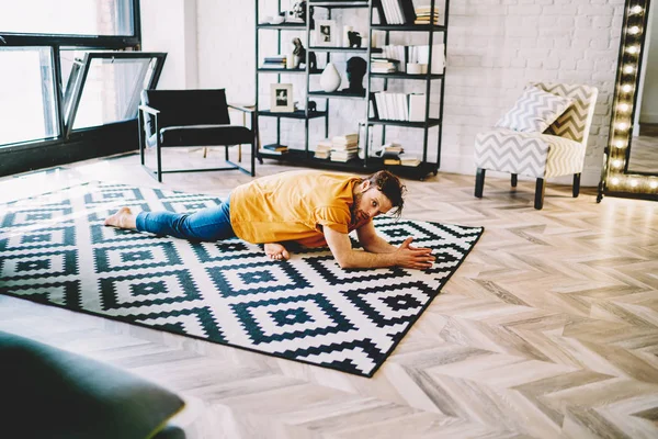 Junger Mann Macht Dehnübungen Auf Gemütlichem Teppich Flexibilität Entwickeln Und — Stockfoto