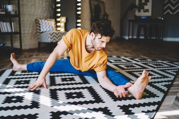 Motivierter Junger Mann Der Zwirn Auf Teppich Sitzt Bei Yoga — Stockfoto