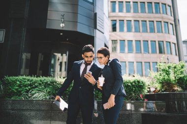 Konsantre erkek ve kadın çalışanlar, finans bölgesindeki kamu kablosuz ağına bağlı olarak şirket müdüründen e-posta aldılar, iş ortakları cep telefonlarıyla çevrimiçi sohbet ediyorlar.