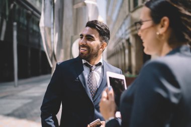 Mutlu Türk erkek bankacı, kadın meslektaşının komik şakasına gülüyor ve birlikte çalışmaktan keyif alıyor. Pozitif ekonomistler açık havada konferans hakkında konuşurken gülümsüyor.