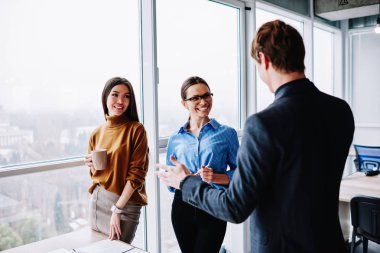 Erkeklerin kahve molasında kadın meslektaşlarıyla yaptığı sohbete, bilgi açıklayan mutlu iş kadınları müşterilerinin toplantı sırasında pazarlama stratejisi hakkında konuştuklarını dinleyen mutlu iş kadınları.