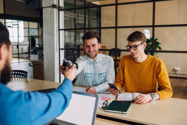 Olumlu hipster elemanları yeni projede işbirliği yaparken klasik kamerayı tartışıyorlar modern ofiste masaüstünde oturuyorlar. Üniversitede ilginç dersler sırasında başarılı öğrenciler gülüyorlar.
