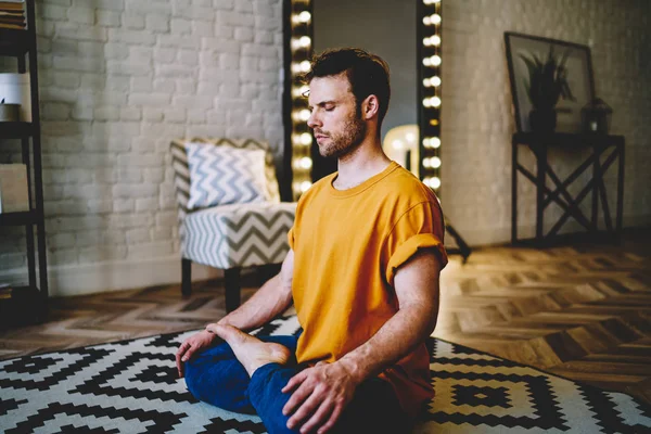 Nyugodt Fiatalember Csukott Szemmel Lótuszban Pózol Kényelmes Szőnyegen Meditál Reggel — Stock Fotó