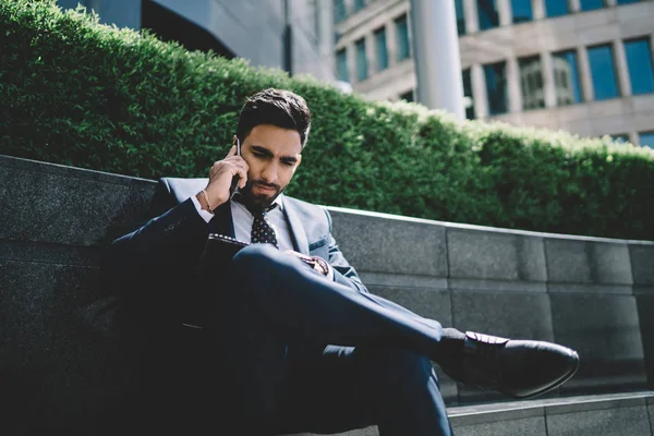 Serious turkish male proud ceo checking information from accounting during important international conversation with business partner, man in formal suit talking with employee about data report