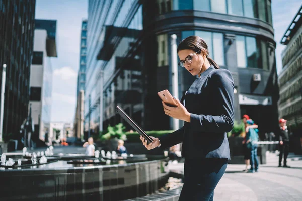 深刻な原因アジアの女性起業家が手元のフォルダで金融街を歩き回り 経済学者のためのウェブページ上でオンラインでチャット 携帯電話で4Gのワイヤレスに接続されたインテリジェントな女性 — ストック写真