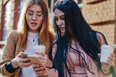 Kafkasyalı genç kadınlar modern akıllı telefon uygulamasını kahve eşliğinde gezmek için kullandılar. Hippi kızlar sokakta dikilip cep telefonlarını kullanarak 4G bağlantısı üzerinden multimedya paylaşıyorlar.