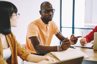 Afrika kökenli Amerikalı erkek koç öğrencilere planlama ve iş stratejilerini, birbirleriyle konuşan yetenekli meslektaşları ve beyin fırtınası oturumlarında yaratıcı çözümleri paylaşıyor.