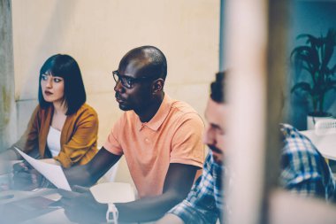 Dersleri dikkatle dinleyen çok ırklı erkek ve kadın öğrenciler, birlikte masaüstünde oturan ve otobüslerle ilgili ortak fikirleri paylaşma üzerine proje stratejisi planlayan yetenekli çalışanlardan oluşan bir ekip.