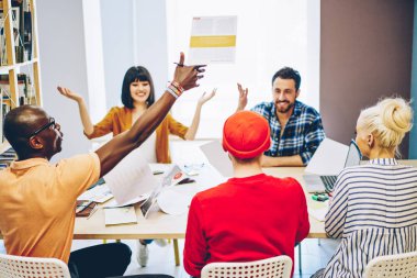 İşbirliğinde başarılı bir projeyi kutlayan çok ırklı çalışanlardan oluşan mutlu bir ekip. Toplantıda beyin fırtınası sonucu heyecanlanan erkek ve kadın iş arkadaşları.