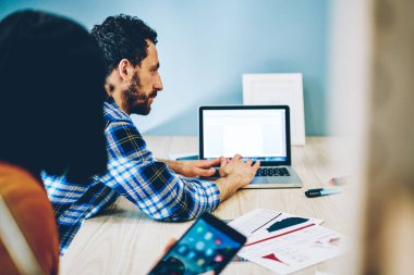 Kadın meslektaşla yaptığı görüşmede dizüstü bilgisayardaki yetenekli sakallı erkek göz gezdirme bilgilerinin kırpılmış görüntüsü. Milenyum adamı, Netbook aracılığıyla proje planlama uygulaması kullanıyor.