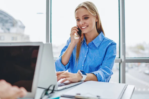 Neşeli Bayan Yönetici Ofisteki Müşteriyle Akıllı Telefondan Konuşurken Modern Netbook — Stok fotoğraf