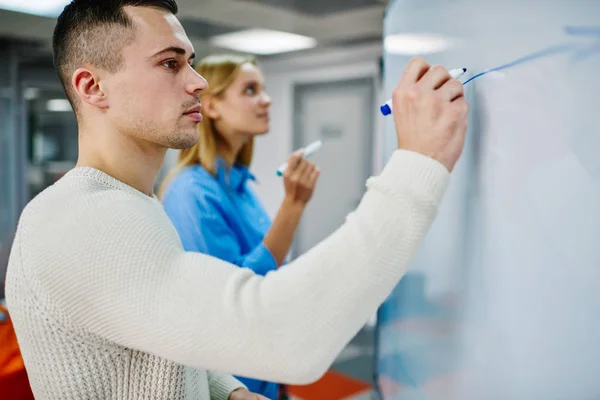 Pensive Young Man Woman Drawing Diagram White Flip Chart Studying — Stock Photo, Image