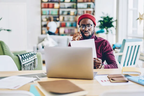 Ernsthafter Afrikanisch Amerikanischer Hipster Typ Der Dokumente Liest Und Hause — Stockfoto