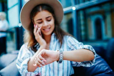 Boş zamanlardaki telefon konuşmaları sırasında kadın kol saatine odaklan, Kafkas kadın buluşmayı planlıyor dışarıda oturan arkadaşına cep telefonu görüşmesi yapıyor ve dinleniyor