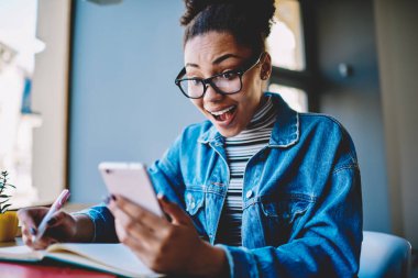 Mutluluk ve pozitif ifade kavramı, koyu tenli, genç bir bayanın aldığı e-postada 4G 'ye bağlı favori web mağazası için büyük indirim bilgisiyle şoke olması.
