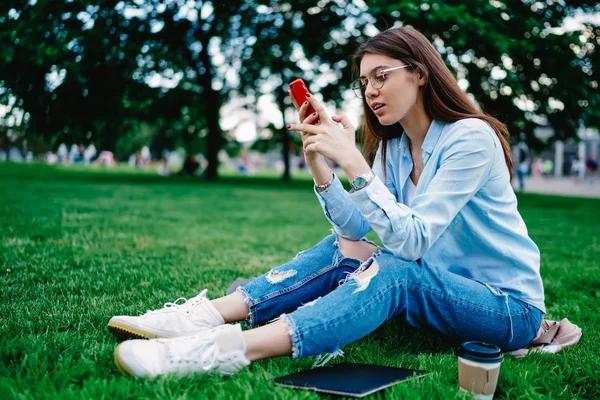 Urocza Młoda Kobieta Siedząca Zielonej Trawie Czytająca Wiadomości Stronie Internetowej — Zdjęcie stockowe