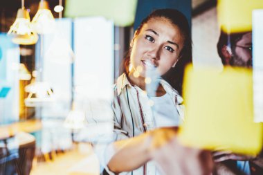Ciddi Asyalı bir kadın projeyle ilgili yaratıcı fikirleri düşünürken ışıklarla birlikte çalışan genç ve zeki bir kız öğrenci yeni bir hayata başlamayı düşünüyor.