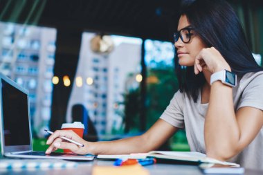 Gözlüklü, vizyon düzeltmesi için gözlüklü bir kadın serbest meslek için dizüstü bilgisayarda rezervasyon yaptırıyor. Yetenekli kız öğrenci internet üzerinden dil dersini öğreniyor.