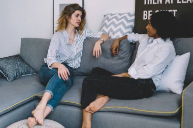 Kafkasyalı genç bir kadın modern dairede rahat bir kanepede dinlenen Afrikalı Amerikalı bir arkadaşıyla konuşuyor. İki çok kültürlü blog yazarı evde dinleniyor ve birbirleriyle konuşuyorlar.