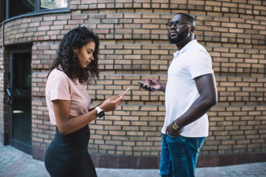 Hüzünlü genç adam, sosyal ağlarda internet üzerinden iletişim kurmaya konsantre olurken, elinde internet ve cihaz bağımlısı cep telefonu tutan bir kadın, konuşmayı görmezden geliyor.