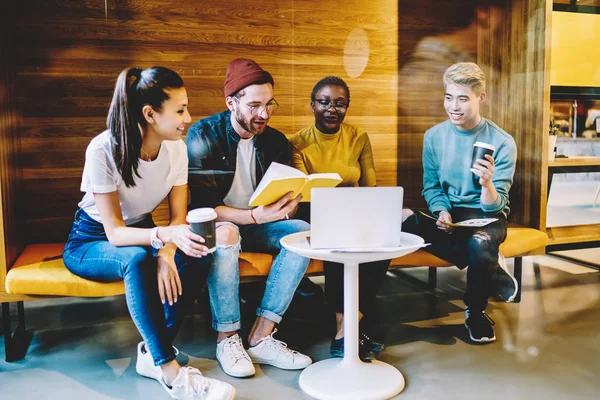 Group of multicultural students together with african american teacher preparing for upcoming exams during private lesson sitting at laptop computer.Team of diverse young people consulting with coach