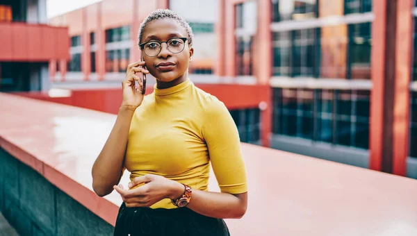 Серйозна Молода Темношкіра Жінка Окулярах Робить Мобільний Телефонний Дзвінок Роумінгу — стокове фото