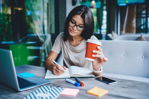 Étudiante Concentrée Écrivant Dans Carnet Tout Apprenant Avec Une Tasse — Photo