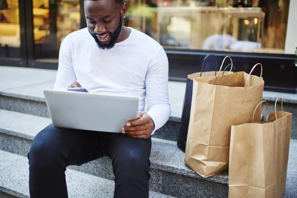 Smiling Afro American Male Customer Sitting Stairs Store Waiting Sms — Foto de Stock