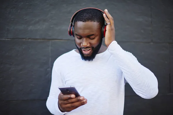 Dark Skinned Hipster Guy Updating Music App Mobile Phone Download — Stock Photo, Image