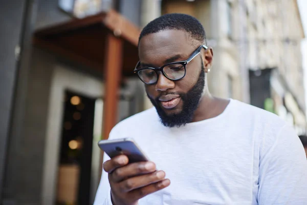 Millennial Dark Skinned Man Using Smartphone App Booking Online While — Zdjęcie stockowe