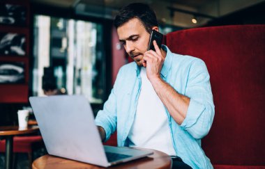 Ciddi bir serbest çalışan bilgisayar antivirüsü hakkında danışmanlık için müşteri hizmetlerini arıyor, erkek programcı cep telefonu uygulaması üzerinden telefon ederken bilgiyi başlatıyor