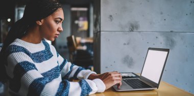 İnternet metni tanıtımı için dijital netbook üzerinde uzaktan çalışan genç kadın programcı, Afrikalı kadın metin yazarı modern dizüstü bilgisayarın klavyesinde web sitesi için yazı yazıyor