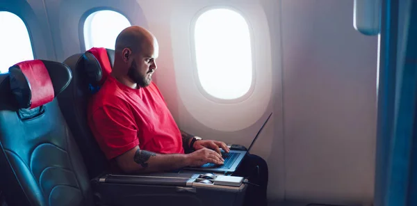 Молодий Чоловік Летить Пасажиром Підключається Бездротового Інтернету Борту Ноутбуком Сидячи — стокове фото