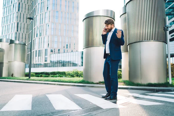 Side view of serious male corporate director calling to partner for solving problems with business contract discussing details of trouble, puzzled boss making international conversation via cellular