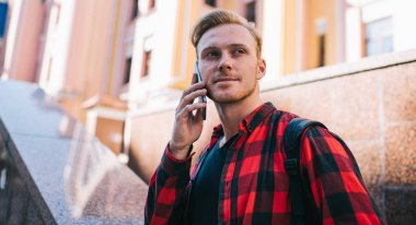 Telefonda konuşan ve caddeye bakan adam.