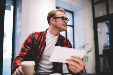 Tabletli ve içkili bir adam kafeye bakıyor.